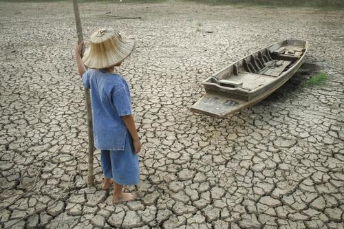 child looking at boat on dry land