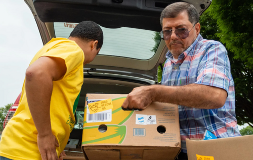 men moving groceries out of a car