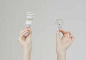 person holding two light bulbs